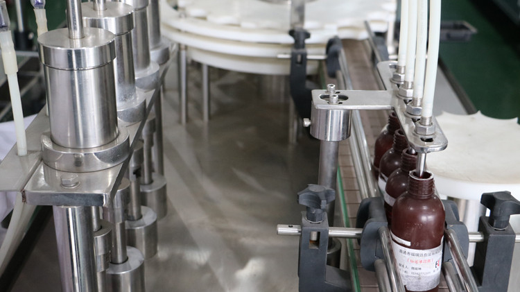 క్యాప్ సీలింగ్ మరియు స్టార్ వీల్ రన్నింగ్‌తో 500 ఎంఎల్ రౌండ్ బాటిల్ ఫిల్లింగ్ మెషిన్